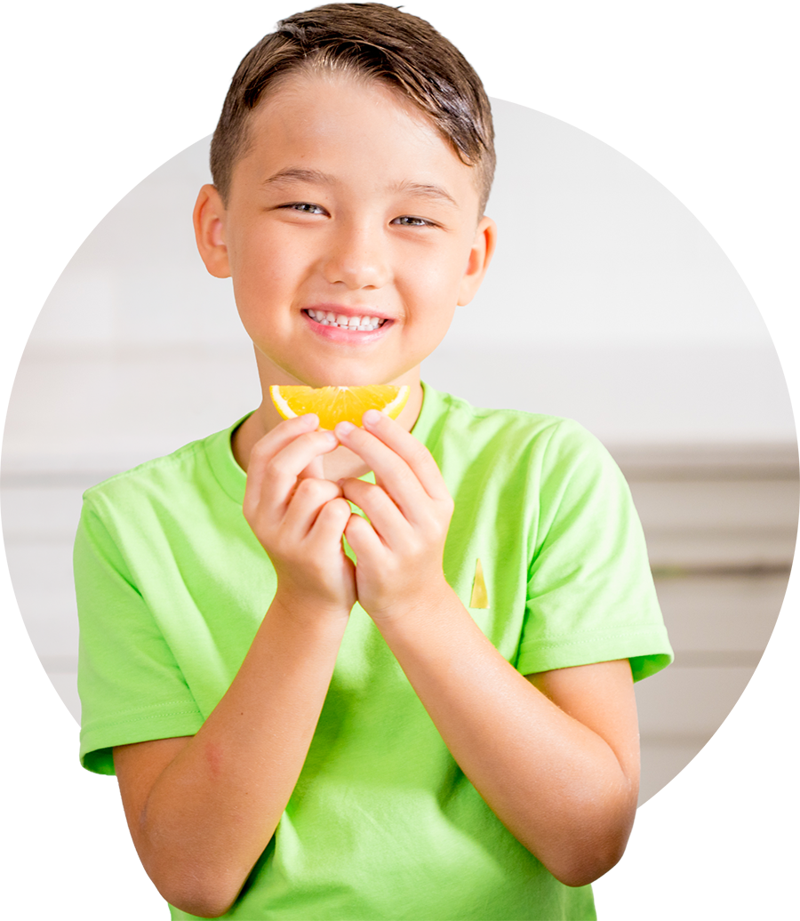 Smiling child holding an orange slice